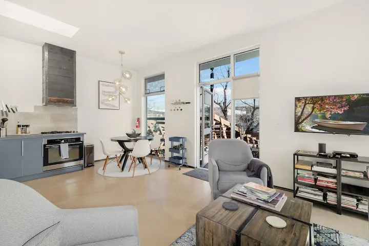 Airy Santa Fe rental with skylight, gray cabinets, and French doors opening to a patio