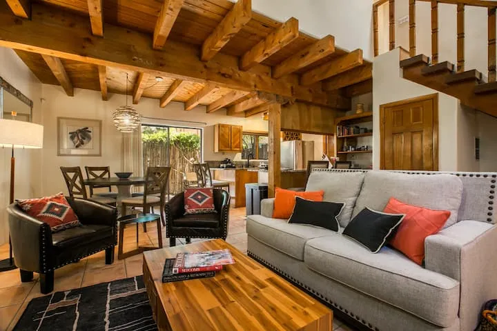 Open-plan Santa Fe home with viga beam ceiling, staircase, and Navajo-pattern accent pieces
